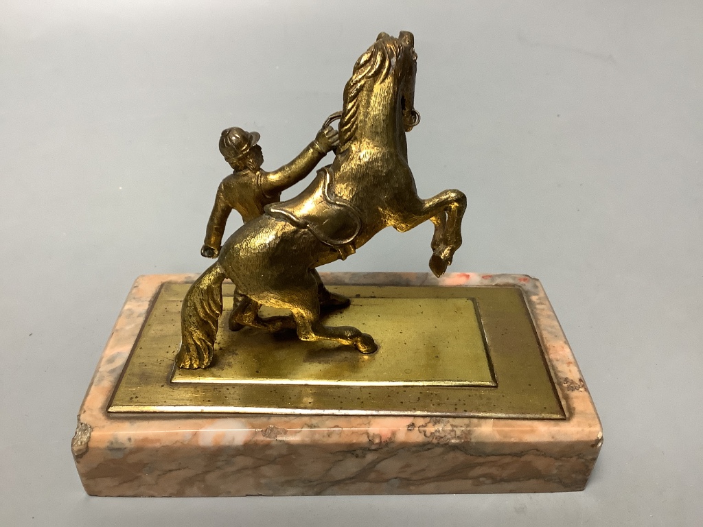 An early 20th century gilt metal group of a horse and jockey, on marble base, length 13cm